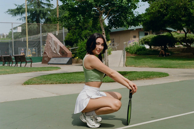 Woman in athletic wear holding a tennis racket on a tennis court.
